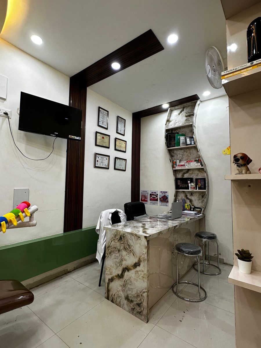 Consultation area with framed credentials and a marble desk at Happy Tooth, Pune